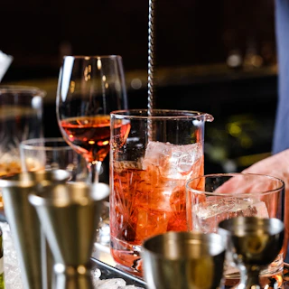 Ground-to-glass cocktails served in an artful basement. A bartender mixes a rye old fashioned.