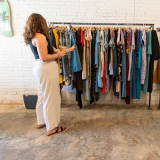 Someone shops for vintage clothes at The Fuzzy Needle on Chapel Hill St, West End, Durham, NC.
The Fuzzy Needle offers diverse vinyl and book collection; supporting independent artists and writers and sharing them with the community. Finding and sharing books, music, and ephemera from the gone world.