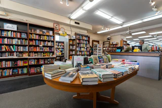 Photo of the interior of The Regulator bookshop. There is a table and shelves filled with books. The community-oriented space regularly hosts author-led readings and book signings with recommended reading lists from staff, local Durham book groups and area librarians.