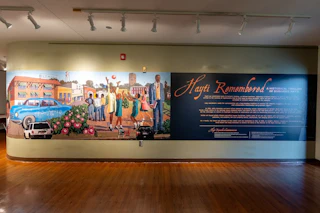 A large mural honoring Black Wall Street adorns an inside wall at Hayti Heritage Center.