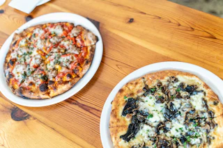 Photo of two plates with pizza at Pizzaria Toro