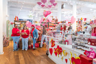 People browse local products among festive red and pink Valentine's Day decorations at Parker & Otis.