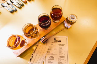 A flight of drinks sit on the table next to a menu at Ment Beverage in Durham, NC.