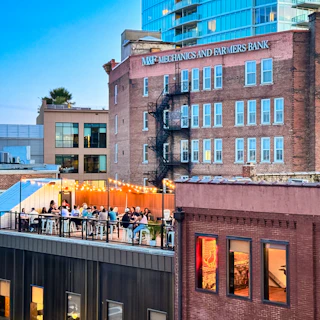 People dine on the stunning rooftop patio at The Velvet Hippo, a neighborhood bar serving fanciful cocktails and mocktails, wine, slushes, local beers and light bites.
A welcoming space complete with rooftop views of downtown; located on Orange Street in historic downtown Durham, City Center district.