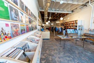 Records, vintage clothes, and used books bathe in sunlight at The Fuzzy Needle in Durham, NC.