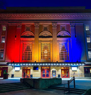 Durham flag colored lights cover the exterior of the Carolina Theatre in Durham, NC.
