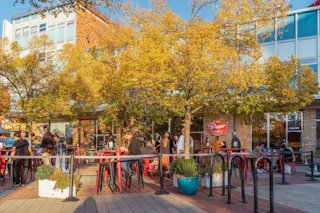 Customers enjoy drinks and food on the patio at Pour Taproom on a sunny, early fall day.