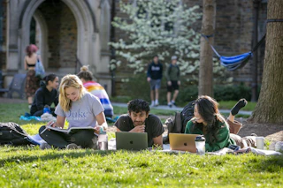 Students sit on the lawn studying and socializing at Duke University.