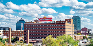 Downtown Durham skyline with the Chesterfield's red "Visitors Welcome" sign prominent in the foreground