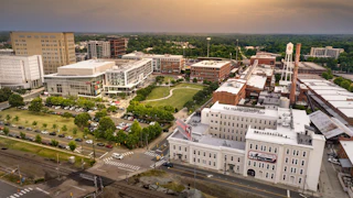 American Tobacco aerial photo at dusk. DPAC, ATC campus, old bull sign, and lucky strike water tower visible. Photo taken June 2023.