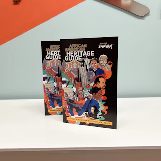 Two open copies of the Durham African American Heritage Guide stand on a tabletop.